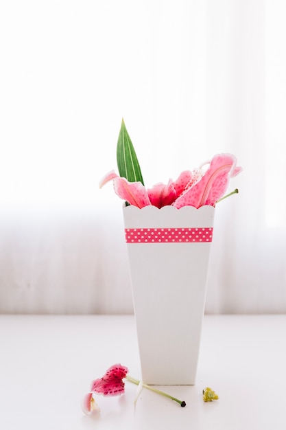 Foto gratuita tazza di carta con petali di giglio