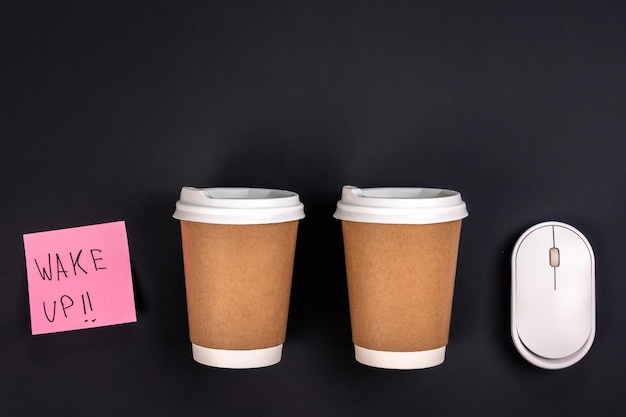 Free photo paper cups computer mouse and paper sticker on a dark background top view