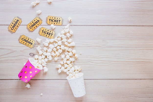 Paper cups with popcorn and tickets