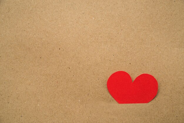 Paper cut out red heart stuck inside the cardboard