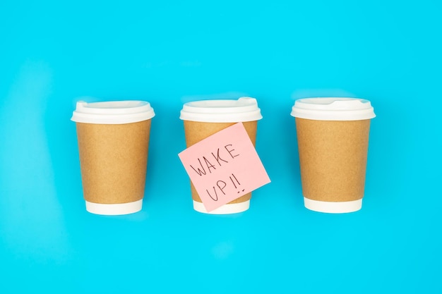 Free photo paper disposable cups and paper reminder with text wake up