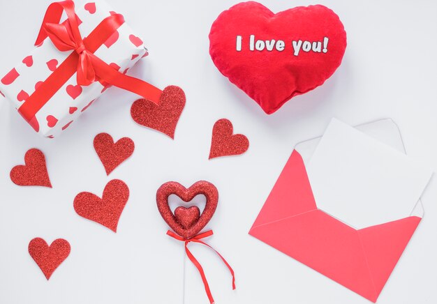Paper in envelope near present and ornament hearts