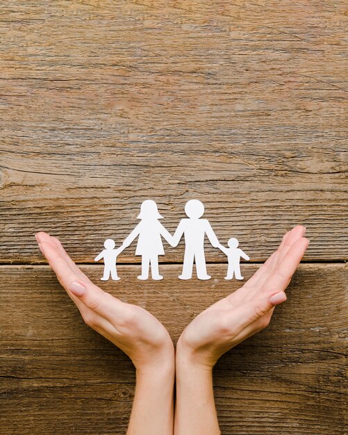 Paper family composition on wooden background with copy space