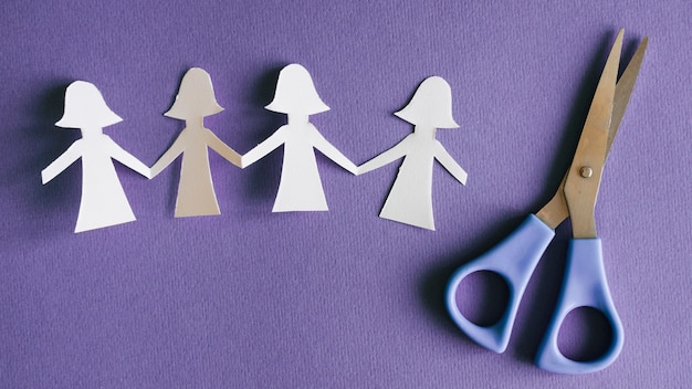 Paper female figures and scissors