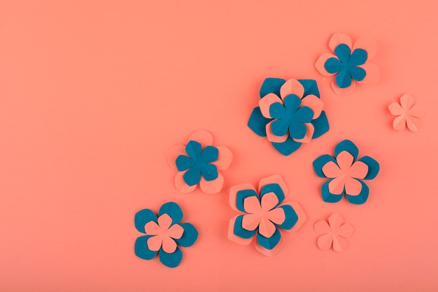 paper flowers and leaves on coral background