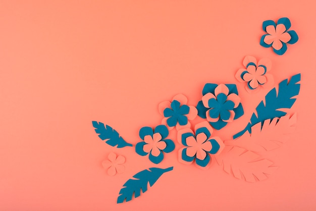 Бумажные цветы и листья на коралловом фоне