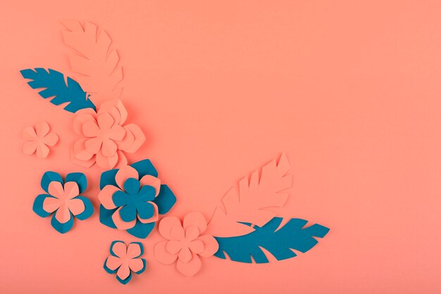 Paper flowers and leaves on coral background