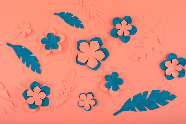 Free photo paper flowers and leaves on coral background