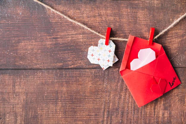 Free photo paper heart and envelope with pins hitching on twist