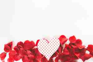 Foto gratuita cuore di carta su petali di fiori