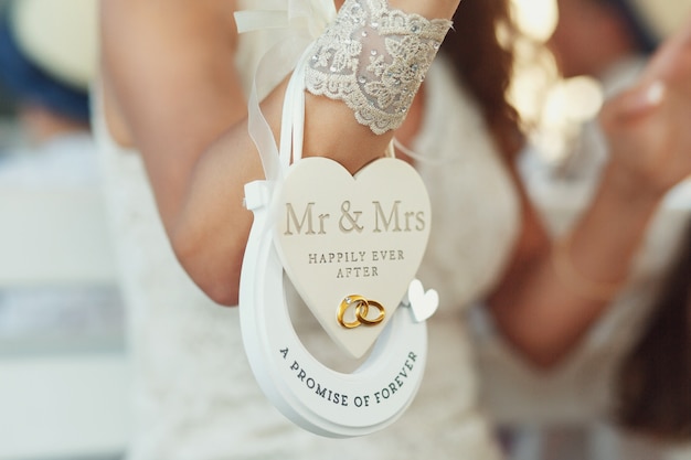 Бумажное сердце «Мистер и миссис счастливо после» и подкова «Обещание навсегда» висят на вершине невесты