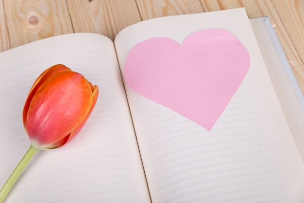 Paper heart and rose in book