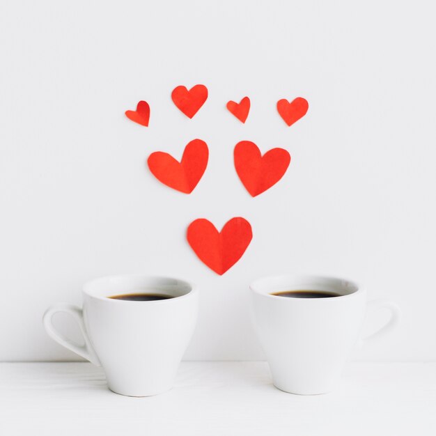 Paper hearts between coffee cups