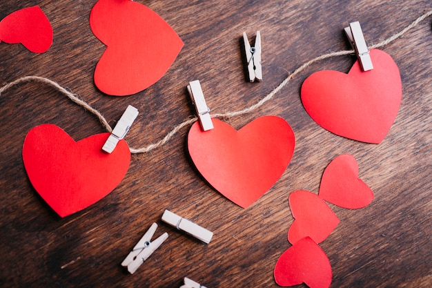 Paper hearts pinned to rope on brown table