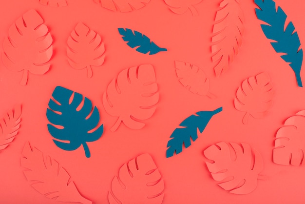 Free photo paper leaves on coral background