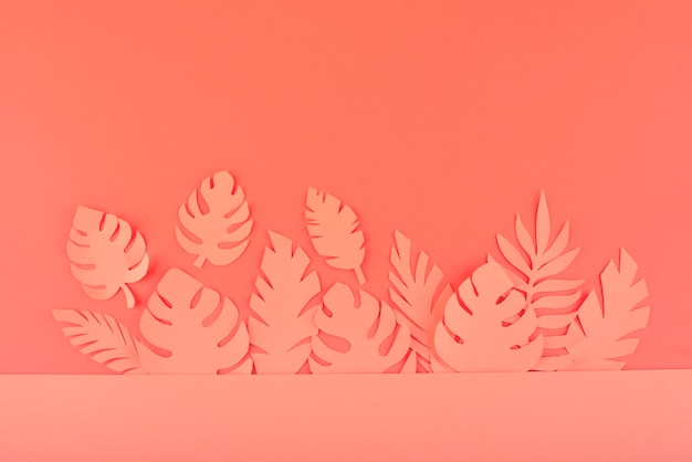 Paper leaves on coral background
