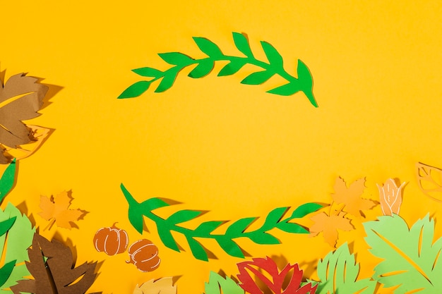 Paper leaves on yellow background