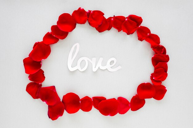 Paper Love inscription with rose petals on grey table