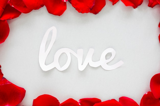 Paper Love inscription with rose petals on light table