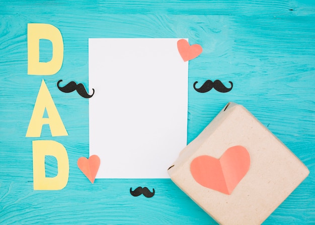 Free photo paper near box with red hearts, mustache and dad title