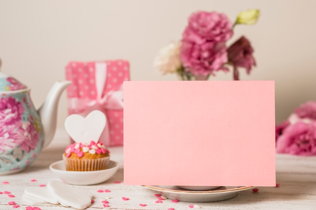 Paper near delicious cake, present box and teapot