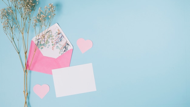 Paper near envelope, decorative hearts and plant 