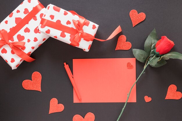 Paper near pen, ornament hearts, flower and presents 