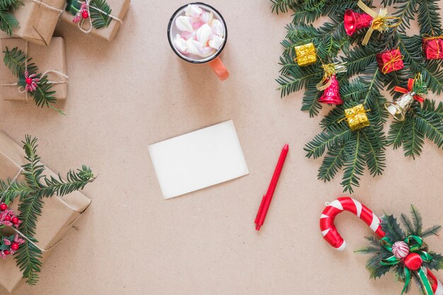 Paper near pen, present boxes, Christmas twig and cup 