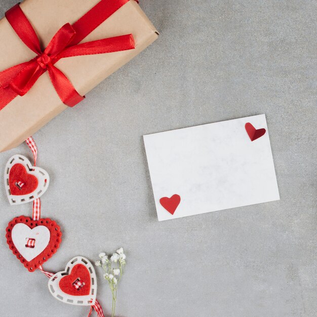 Бумага рядом с подарком и украшением сердца