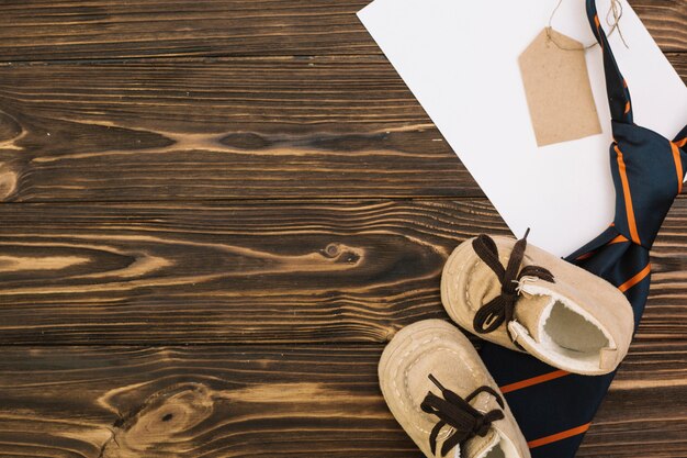 Paper near striped tie with tag and kid shoes