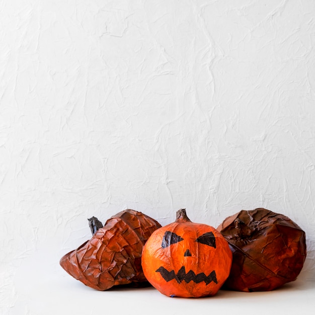 Paper pumpkins near spooky jack-o-lantern