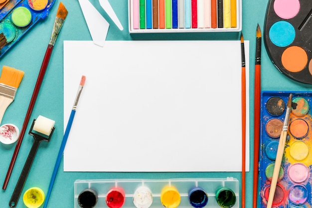 Paper sheet and artist painting tools on desk