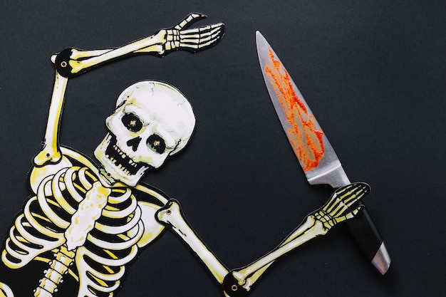 Paper skeleton with bloody knife