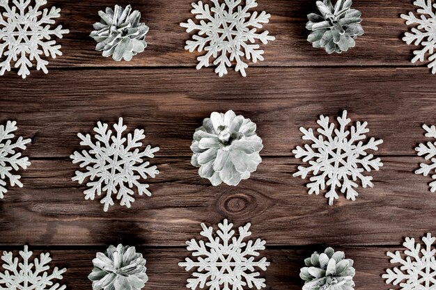 Paper snowflakes and light snags on wooden board