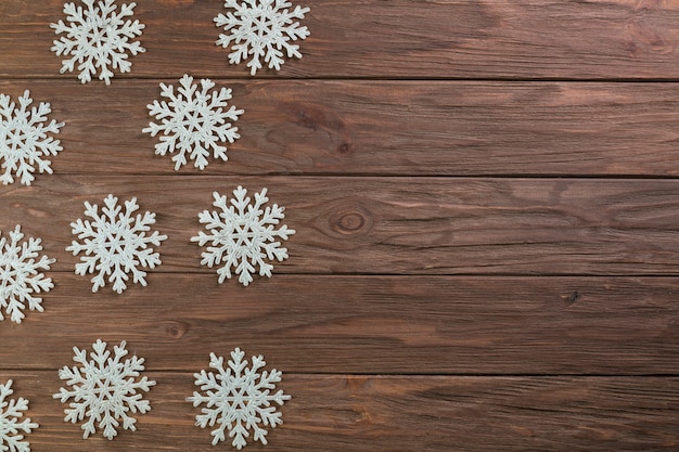 Fiocchi di neve di carta sul bordo di legno