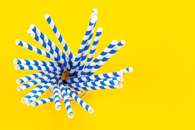 Free photo paper straws for drinks on a yellow background top view