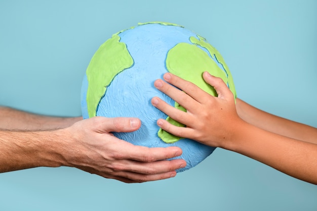 Paper style earth globe shape in hands