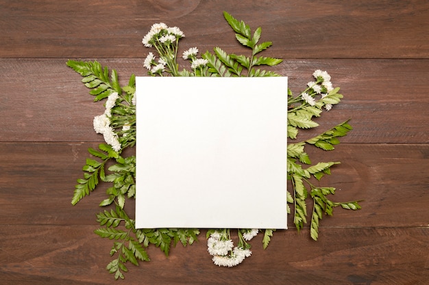 Free photo paper surrounded by green leaves