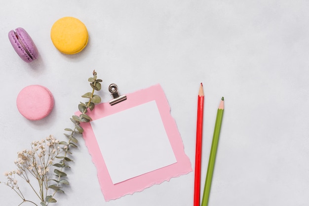 Free photo paper with macaroons and flower branch on table