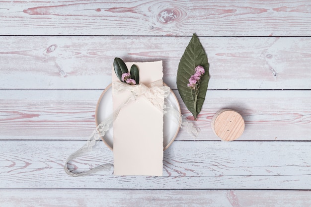 Free photo paper with petals and band on plate near leaf