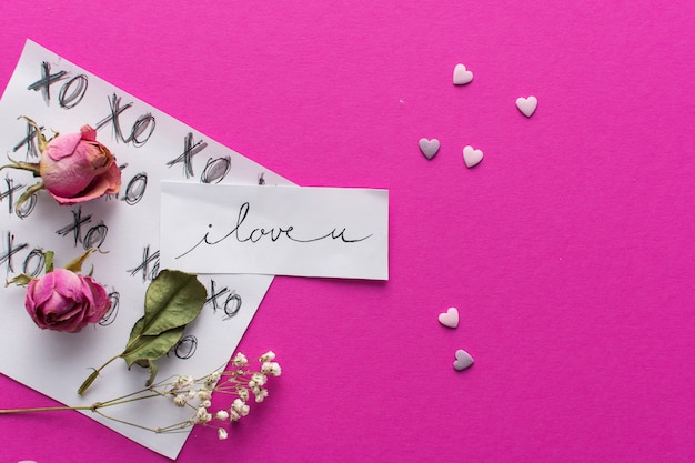 Paper with title near ornament hearts and set of flowers