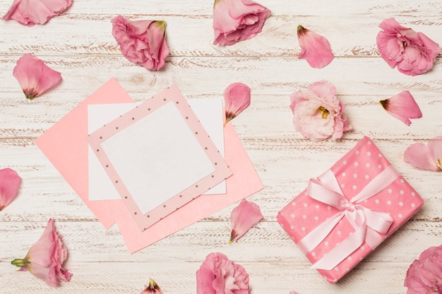 Free photo papers between flowers near gift box