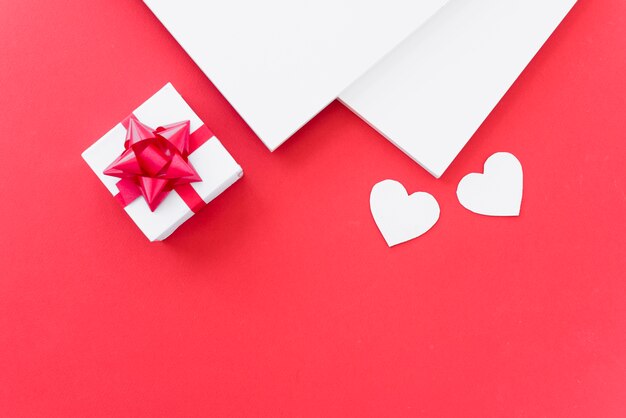 Papers near ornament hearts and present box 