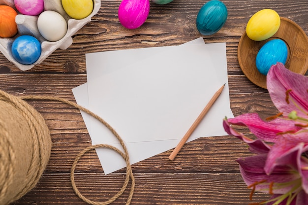 復活祭の卵、糸、新鮮な花のセット近くの論文