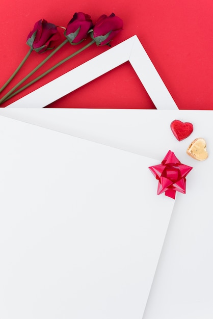 Papers with ornament hearts and bow near blooms