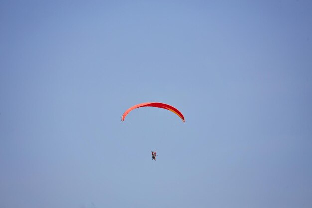 Paragliding in the sky Paraglider flying in bright sunny day Beautiful paraglider in flight on a turquise background