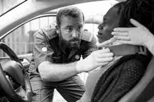 Free photo paramedic placing a cervical collar to an injured woman from car accident