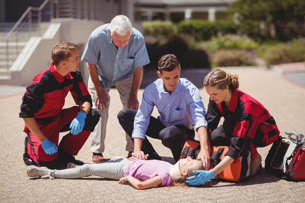 Paramedics examining injured girl