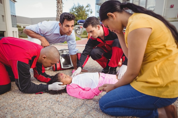 Free photo paramedics examining injured girl