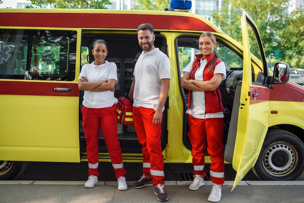 Парамедики на работе с машиной скорой помощи Медсестра и врач скорой помощи в машине скорой помощи с комплектом